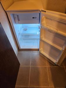 an empty refrigerator with its door open in a kitchen at Hiška Polhec in Bovec