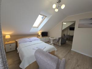 a bedroom with a bed and a window and a chair at Mirato in Władysławowo