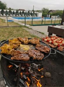 a bunch of meat and other food on a grill at Casa Diadeea Motru in Motru