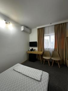 a hotel room with a bed and a desk at Casa Diadeea Motru in Motru