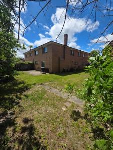 a large brick building on a grass field at Bright Cozy 2-Bedroom Main Floor Suite in Brampton