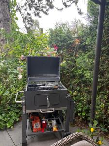 a grill sitting on a stand in a garden at La Luna in Lanaken
