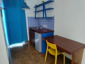 a kitchen with a wooden table and a yellow chair at Bayahibe Premium Pool in Bayahibe