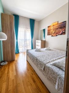 a bedroom with a bed and a large window at SeaSideApartamn in Boreti
