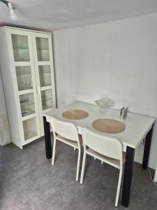a kitchen with a white table and two white chairs at T1 Amadora in Amadora