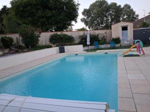 a swimming pool with a slide in the middle at La Piaule in Saint-Pierre-le-Vieux