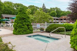 a swimming pool in a yard with trees at Juniper Hill Inn in Ogunquit