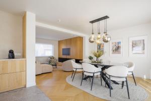 a dining room and living room with a table and chairs at The Edewallenaar in Kortemark