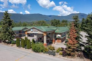 an image of the front of a hotel with trees at SureStay Plus Hotel by Best Western Salmon Arm in Salmon Arm