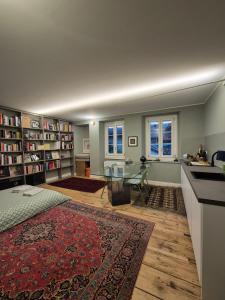 a living room with a glass table and bookshelves at Loft Library by Lago Maggiore Rentals in Oggebio