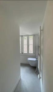 a white bathroom with a tub and a window at Loft Library by Lago Maggiore Rentals in Oggebio