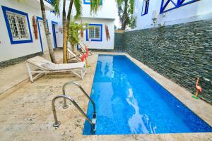 a swimming pool with a couch and a chair at Bayahibe Premium Pool in Bayahibe