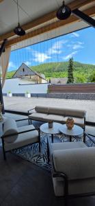 eine Terrasse mit Sofas und Tischen und einem großen Fenster in der Unterkunft Glamping L tiny , 2Ferienhäuser mit stillvolles Design und hohem Komfort Sauna Hot Tub in Platten