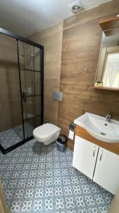 a bathroom with a toilet and a sink and a shower at orhan pansiyon in Çeşme