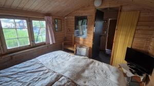 a bedroom with a bed in a room with windows at Paradise cottage w sea view in Brännöviken 5, Lögdeå in Lögdeå