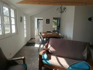 a living room with a couch and a table at L'Olivier des Dunes in Saint-Georges-dʼOléron