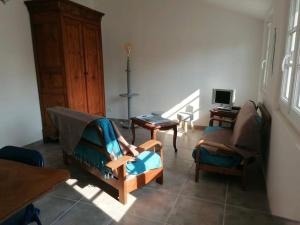 a living room with a chair and a desk at L'Olivier des Dunes in Saint-Georges-dʼOléron