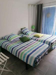 two beds sitting next to each other in a room at L'Olivier des Dunes in Saint-Georges-dʼOléron +4 photos