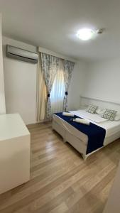 a bedroom with a bed and a wooden floor at orhan pansiyon in Çeşme