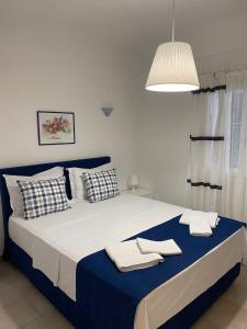 a bedroom with a large bed with towels on it at Glyfada Corfu Apartment in Glyfada +22 photos