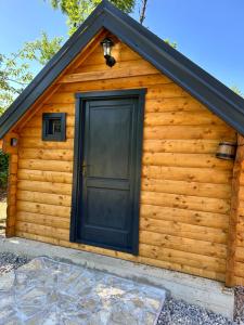 a log cabin with a black door at Log Cabin in Blatina