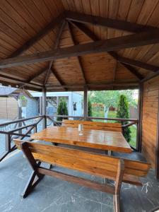 a large wooden table in a pavilion at Мигдаль Маєток in Svityazʼ