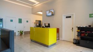 an office with a yellow counter in a room at Golden Tower Maracanaú by Fênix Hotéis in Maracanaú