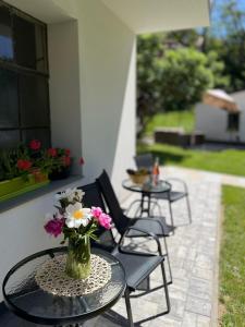 a table with a vase of flowers on a patio at JUNÁK MINI ubytování v soukromí in Vranov nad Dyjí