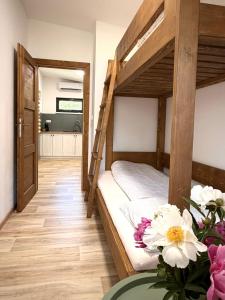 a bedroom with two bunk beds with flowers on a table at JUNÁK MINI ubytování v soukromí in Vranov nad Dyjí +7 photos