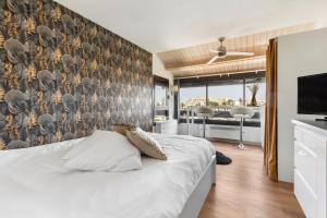 a bedroom with a bed and a wall with a tv at Studio naturiste venus panoramic view in Cap d'Agde +22 photos