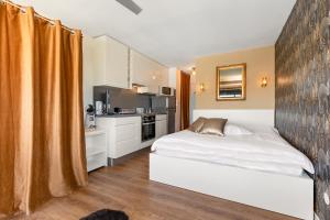 a bedroom with a white bed and a kitchen at Studio naturiste venus panoramic view in Cap d'Agde