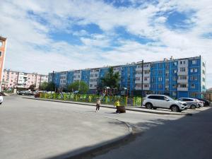 two people are standing on a street with a playground at Yuzhnaya in Qyzylorda