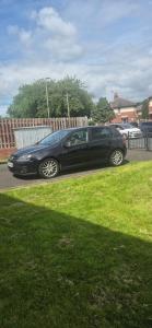 a black car parked in a parking lot at Century Apartments Manchester in Dukinfield