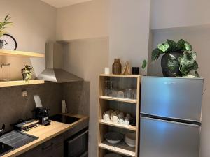 eine Küche mit einem Edelstahlkühlschrank und Regalen in der Unterkunft Skye collection in Tripolis