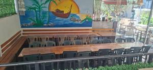a large painting on the wall of a restaurant with chairs at San Marco in Velipojë