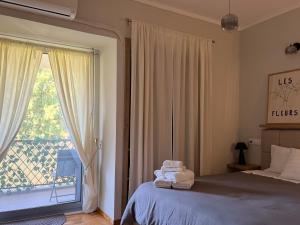 ein Schlafzimmer mit einem Bett und einem großen Fenster in der Unterkunft Skye collection in Tripolis