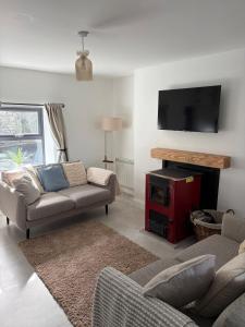 a living room with a couch and a flat screen tv at Rose Cottage, Killala in Killala