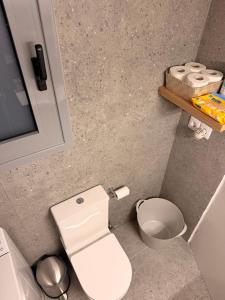 ein Badezimmer mit einer weißen Toilette und etwas Toilettenpapier in der Unterkunft Skye collection in Tripolis