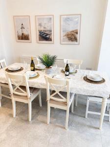 a dining room with a table with chairs and wine bottles at Rose Cottage, Killala in Killala