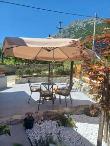 a patio with a table and chairs under an umbrella at Terra Verde in Omiš