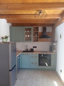 a kitchen with blue cabinets and a wooden ceiling at Terra Verde in Omiš +20 photos
