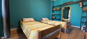two beds in a room with blue walls at Apartments Black Pearl of Ureki in Ureki