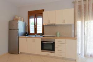 a kitchen with white cabinets and a refrigerator at Villa Nostalgia in Skala Potamias