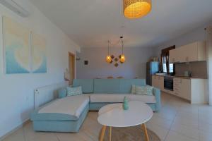 a living room with a blue couch and a table at Villa Nostalgia in Skala Potamias