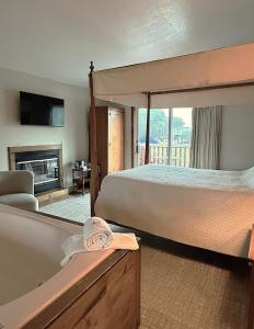 a bedroom with a bed and a tub and a fireplace at Afton House Inn in Afton