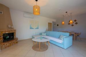a living room with a blue couch and a table at Villa Nostalgia in Skala Potamias