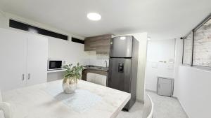 a kitchen with a table and a stainless steel refrigerator at Casa Mama Hotel in Manizales