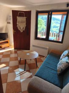 a living room with a couch and a table at Iza sedam gora in Rakovac