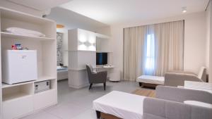 a hotel room with a bed and a living room at Golden Tower Maracanaú by Fênix Hotéis in Maracanaú