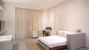a white room with a bed and a chair at Golden Tower Maracanaú by Fênix Hotéis in Maracanaú +32 photos